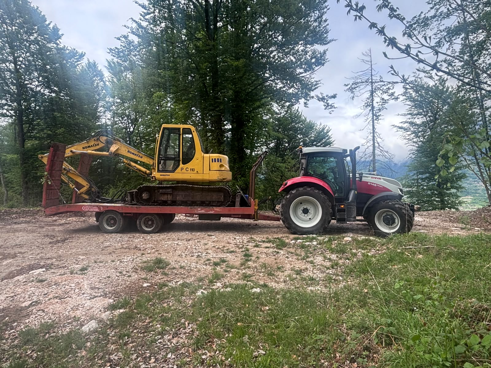 Trattore che trasporta un miniescavatore su rimorchio